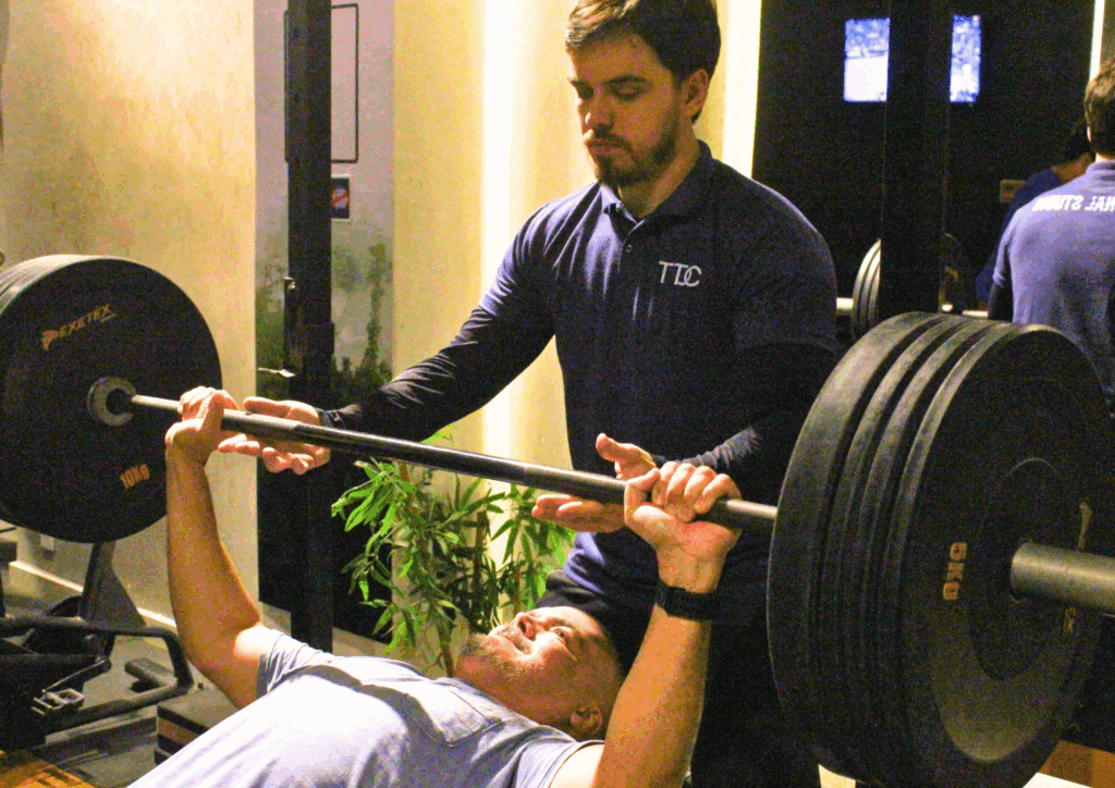 Treinador orientando treino personalizado com foco em recuperação muscular inteligente