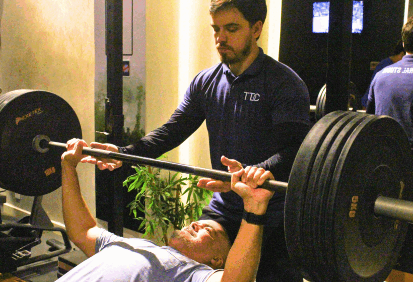 Treinador orientando treino personalizado com foco em recuperação muscular inteligente